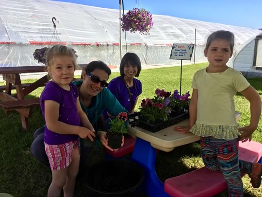 Annabel and Nora planting a Pansy for their Mom 